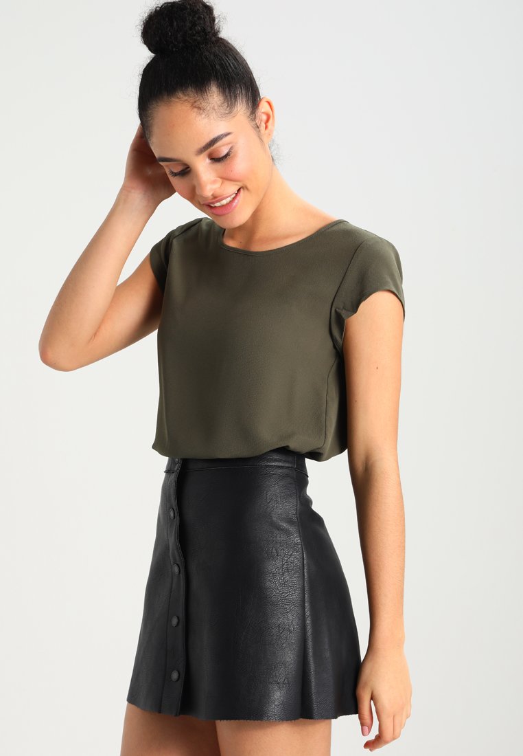Olive green short-sleeve blouse paired with a black faux leather mini skirt featuring a button-down front and A-line silhouette.