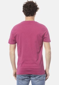 T-shirt a maniche corte di colore magenta uniforme, realizzato in cotone, con scollo rotondo e una consistenza liscia. La vista posteriore non mostra loghi o motivi visibili.