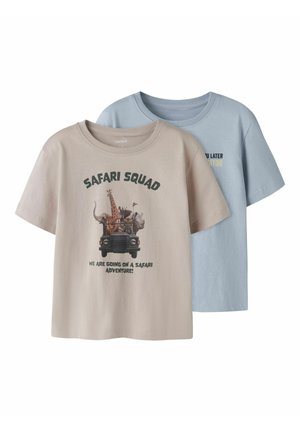 T-shirts enfants beige et bleu clair, beige avec le texte « Safari Squad » et des animaux de safari dans un jeep, bleu avec un texte partiellement visible.