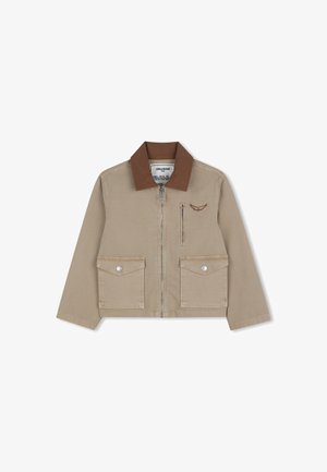 Beige jas met ritssluiting, bruine kraag, twee klepzakken met knopen aan de voorkant, borstzak met rits en een klein logo met vleugels op de linkerborst.