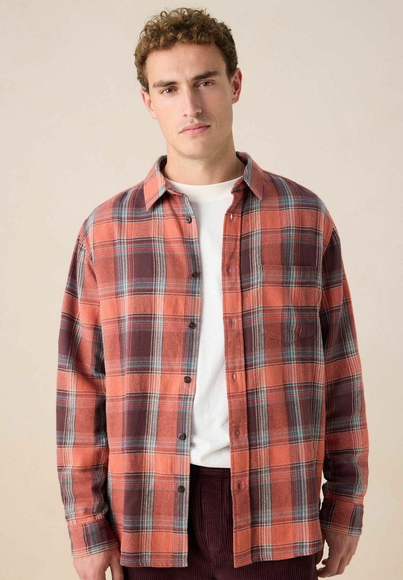 Geruite flanellen shirt in oranje, bordeaux en blauwe tinten; knoopsluiting; lange mouwen; enkele borstzak; zachte textuur.