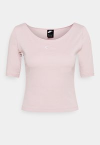 Lichtroze Nike cropped T-shirt met halve mouwen, ronde halslijn en klein wit Nike swoosh-logo gecentreerd op de borst.