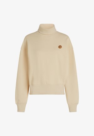 Beżowy sweter z golfem wykonany z miękkiego materiału, z luźnym krojem, opadającymi ramionami i małym okrągłym logo na piersi.