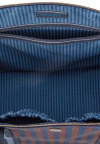 Blue striped interior of a bag with a zippered pocket and gathered fabric at the edges. Label reads "PIP STUDIO."