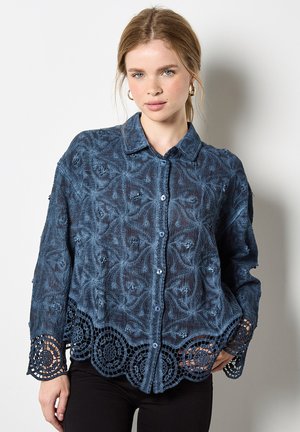 Blaue, strukturierte Bluse mit floralem Stickerei, Knopfverschluss und Spitzenbesatz am Saum. Lange Ärmel und ein Kragen-Design.