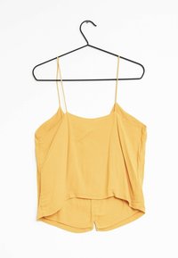 Gul ärmlös topp med tunna band, mjukt tyg, avslappnad passform, rundad nederkant och en något längre bakdel. Hänger från en svart krok.