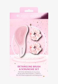 Cepillo desenredante de plástico rosa suave con cerdas texturizadas, acompañado de dos scrunchies de satén rosa; empaquetado en un diseño rosa con acentos.