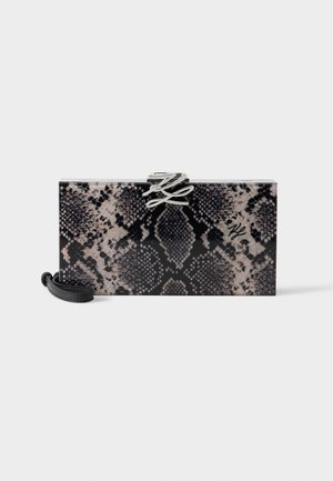 Rektangulær clutch taske med sort og beige slangeskinds mønster, sølv dekorativ spænde og aftagelig sort håndledsrem.
