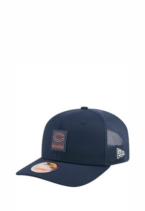 Casquette de baseball bleue marine avec un dos en maille, présentant un patch logo carré avec l'inscription "Chicago Bears" en orange. Sangle réglable et visière plate.