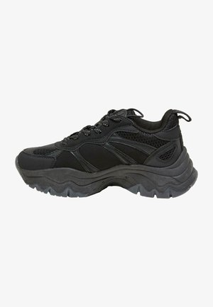 Baskets de sport noires avec semelle épaisse et robuste, tige en mesh et synthétique, fermeture à lacets et col rembourré avec languette à boucle au talon.