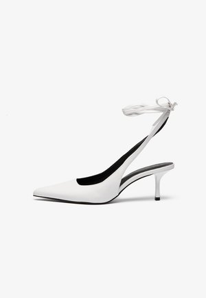 Bílé kožené slingback lodičky s špičatou špičkou, tenkým podpatkem a páskem kolem kotníku zavázaným vzadu; elegantní a moderní designové detaily.