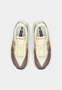 Lightweight athletic sneakers with a beige and brown color scheme, featuring a mesh upper, laces, and a cushioned sole.