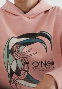 Lichtroze hoodie met een grafisch ontwerp van draaiende turquoise en zwarte vormen en een figuur, met de merknaam "O'Neill Santa Cruz, California, U.S.A."