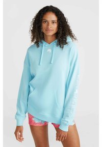 Light blue hoodie made of soft fabric, with a front pocket and drawstring. Features a small logo near the collar and text on the sleeve.