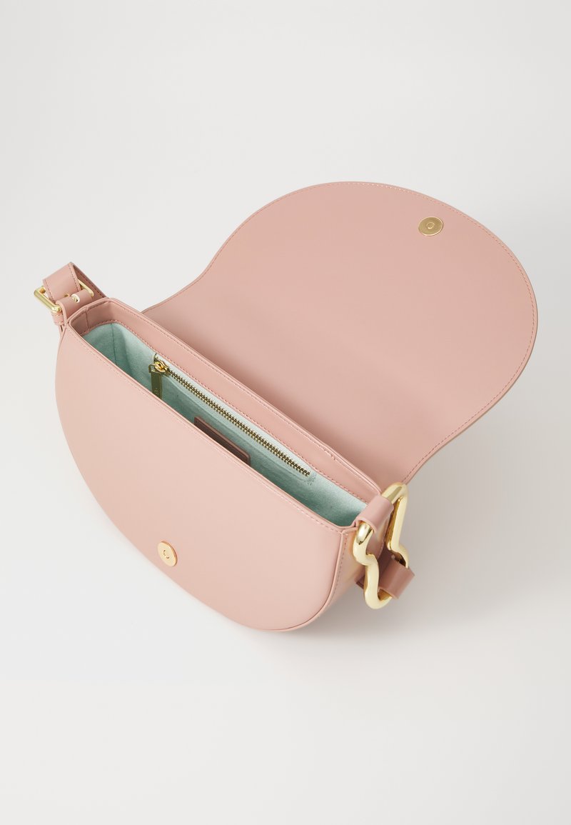 Rózsaszín bőr keresztpántos táska arany fém kiegészítővel, lekerekített formával, nyitott tetejével, és világoskék belső részével, amely cipzáras zsebet tartalmaz.
