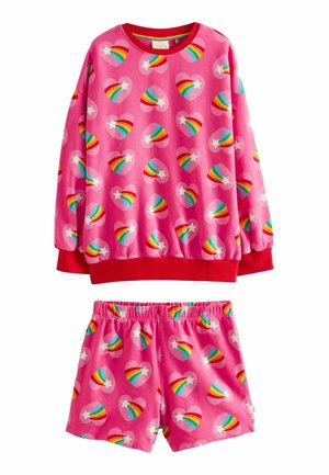 Vaaleanpunainen fleece-yöasu, joka sisältää pitkähihaisen paidan, jossa on sateenkaaren sydänkuvioita ja punaisia hihoja, yhdessä yhteensopivien lyhythihaisten shortsien kanssa, joissa on samankaltaiset kuviot.