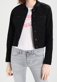Black denim jacket with a fitted design, button closure, front pockets, and long sleeves, worn over a light gray T-shirt and gray jeans.