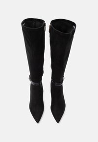 Μαύρες σουέντ μπότες μέχρι το γόνατο με μυτερό μύτο, με λείο φινίρισμα, πλαϊνά φερμουάρ και διακριτική γυαλιστερή λεπτομέρεια με λουράκι κοντά στον αστράγαλο.