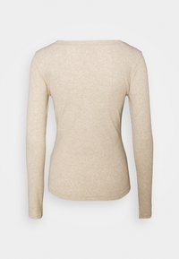 Beżowa bluzka z długim rękawem wykonana z miękkiego materiału. Posiada okrągły dekolt, dopasowane rękawy i prosty brzeg na dolnej krawędzi. Widok z tyłu.