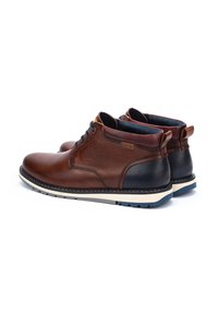 Stivaletti in pelle marrone con accenti blu scuro, punta rotonda, suola in gomma blu, tacco nero e dettagli di cucitura a contrasto.