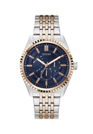 Reloj de pulsera para hombre Guess con esfera azul, marcadores de hora dorados, tres subesferas y correa de eslabones metálicos bicolor en plata y oro.