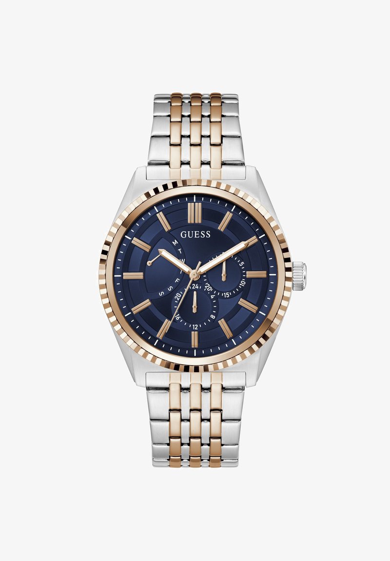 Montre-bracelet Guess pour hommes avec cadran bleu, index dorés, trois sous-cadrans, et bracelet en maillons métalliques bicolores argent et or.