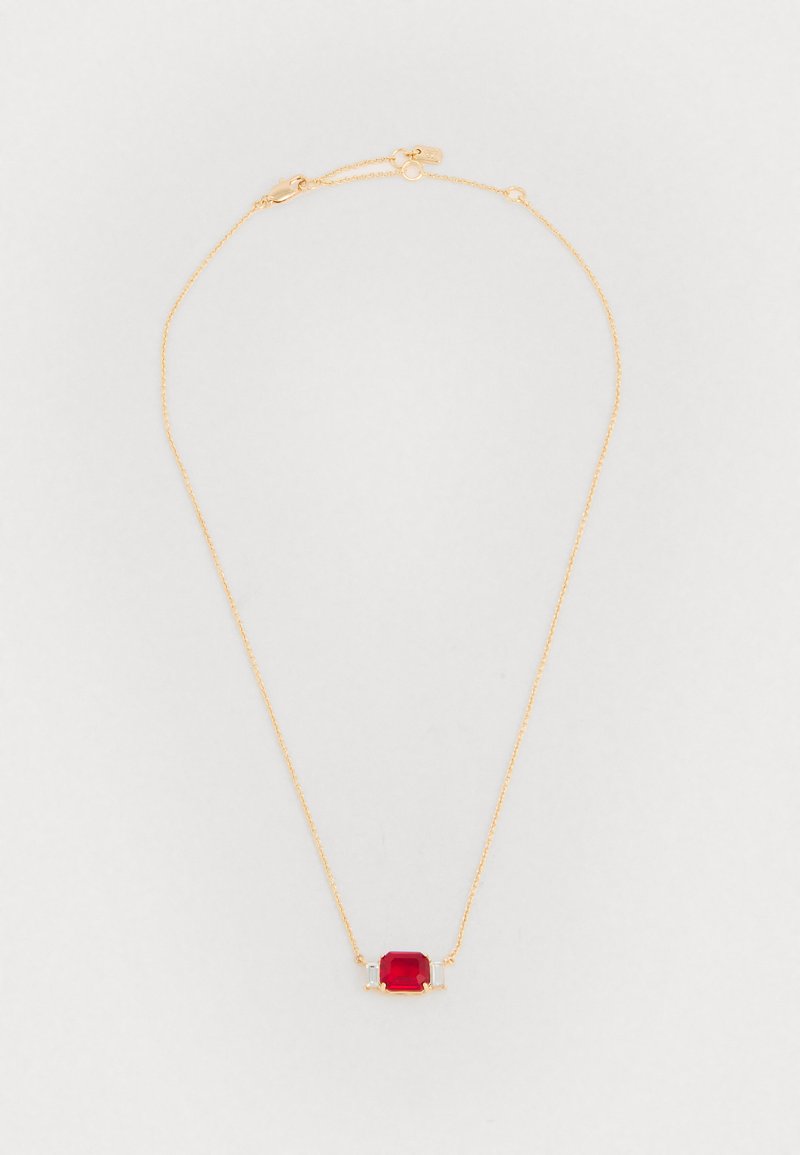 Colar de corrente de ouro com uma gemas vermelha central e dois detalhes claros, com um design delicado e textura suave.