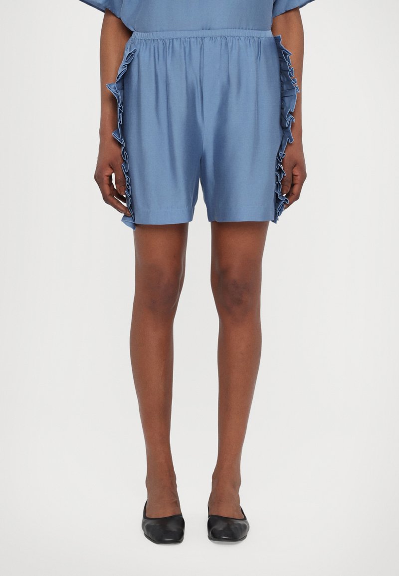 Blue shorts with ruffled detailing along the side, made from a lightweight fabric. Smooth texture, elastic waistband, and hemmed edges.