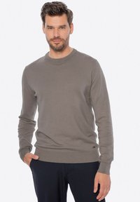 Jasnoszary sweter crew-neck z długimi rękawami, z prążkowanymi mankietami i dołem. Miękka faktura z małym logo w lewym dolnym rogu.