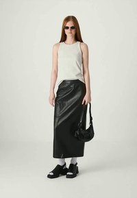 Top de tirantes blanco acanalado, falda larga de cuero negra, zapatos de plataforma negros, un pequeño bolso negro y gafas de sol oscuras. Texturas suaves y líneas simples.