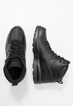 Paire de bottines de sport montantes noires en cuir texturé et tissu, montrant des vues latérales et supérieures sur fond blanc.