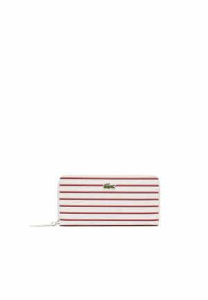 Portefeuille rayé en blanc et rouge, avec une texture lisse, fermeture éclair et un petit logo de crocodile vert sur le devant. Forme rectangulaire.