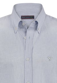Lichtblauw knoopshirt van gestructureerde stof met een klein geborduurd vogeltje op de borst en een standaard knoop-onder-hals.