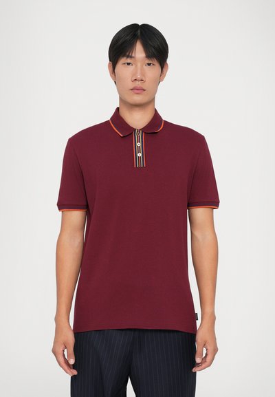 Bordeaux polo shirt met een gestreepte kraag en een drie-knopen sluiting. Korte mouwen met contrasterende afwerking. Glad, lichtgewicht stoftextuur.
