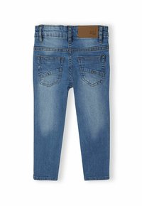 Modre kavbojke slim fit z dvema zadnjima žepoma, rjavim usnjenim oznako na pasu in z blede teksturo pranja.