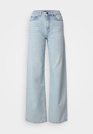 Lys blå bredbente jeans laget av denim. Har høy midje, knappelukking og subtil fading gjennom hele plagget. Tydelig synlig søm.