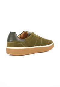 Green suede sneaker with white laces, tan rubber sole, and dark green leather heel accent. Features stitching details along the side.