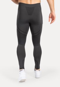 Leggings atletici neri con una fascia in vita testurizzata e dettagli con cuciture curve, caratterizzati da un design aderente e pannelli a contrasto.