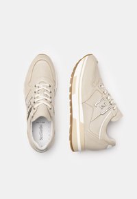 Sneakers in pelle beige con dettagli bianchi, suola testurizzata e linguetta imbottita. Presentano lacci tondi e dettaglio del logo sul lato.