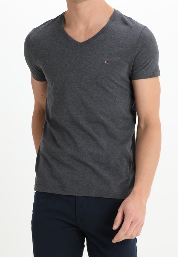 Camiseta de algodón gris con escote en V y mangas cortas. Presenta un pequeño logo bordado en el pecho. Textura suave, ajuste casual.