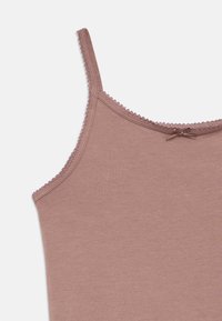 Ανοιχτό ροζ τοπ καμισέ με λεπτές τιράντες, ευαίσθητο διακοσμητικό δαντελωτό τελείωμα και μικρό φιόγκο στο μπροστινό μέρος. Μαλακό, λείο ύφασμα.