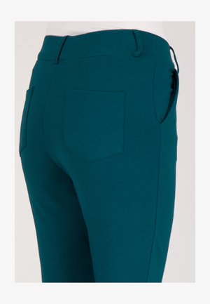 Teal stretchbroek met een gladde textuur, voorzien van een achterzak en een elastische tailleband voor comfort en flexibiliteit.