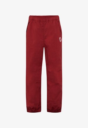 Pantalon léger rouge avec taille et chevilles élastiques, poches latérales et un petit logo circulaire sur la cuisse droite.