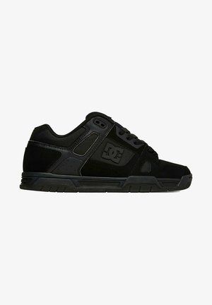 Sorte svarte skate sko med en kombinasjon av matte og teksturerte materialer, med en polstret såle, snøring og logo på siden.