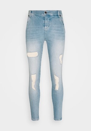 Hellblaue zerrissene Skinny-Jeans mit Knopf- und Reißverschluss, vorderen Taschen und abgenutzten Stellen an beiden Beinen.