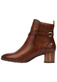 Brown leather ankle boot with ribbed side details, thin strap accent, and a stacked wooden heel. Pointed toe design enhances sleek appearance.