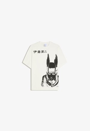 T-shirt blanc avec un dessin noir d'une personne portant un bandeau à plumes et un texte japonais au-dessus du dessin sur le côté gauche.