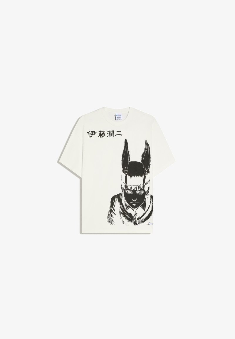 T-shirt blanc avec un dessin noir d'une personne portant un bandeau à plumes et un texte japonais au-dessus du dessin sur le côté gauche.
