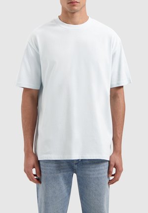 Lichtblauwe katoenen T-shirt met korte mouwen, ronde halslijn en subtiel geborduurd logo op de linkerborst. Slank figuurontwerp, gladde textuur.
