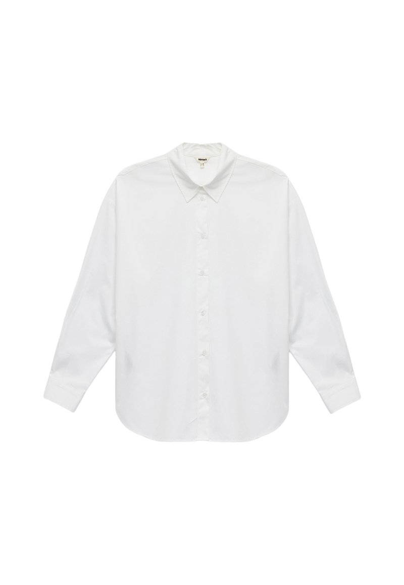 Valkoinen puuvillainen pitkähiha shirt, jossa on klassinen kaulus, napitettava etuosa ja pyöristetty helma. Sileä rakenne, ei kuvioita tai korostuksia.